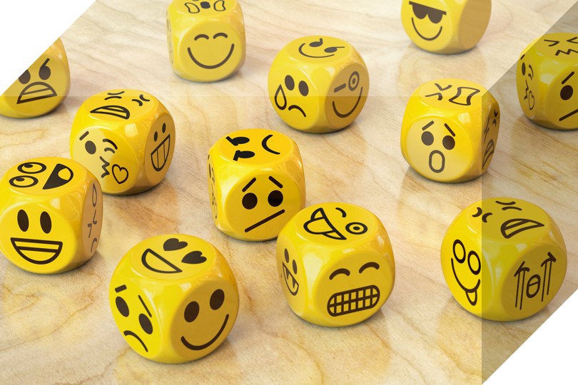 yellow dice with different faces on them depicting different personalities