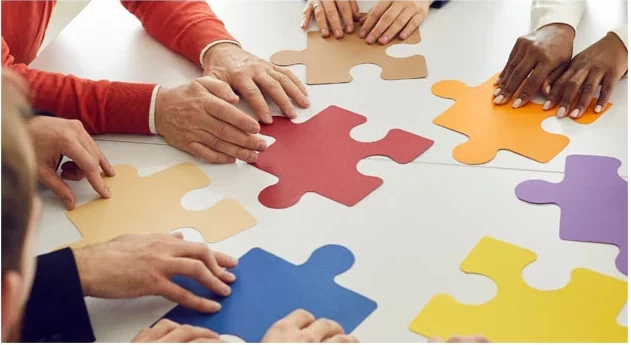 Stop the Firefighting: Empower Your Team and Transform Your Workplace Culture 4 Team working together to combine multicoloured puzzle pieces