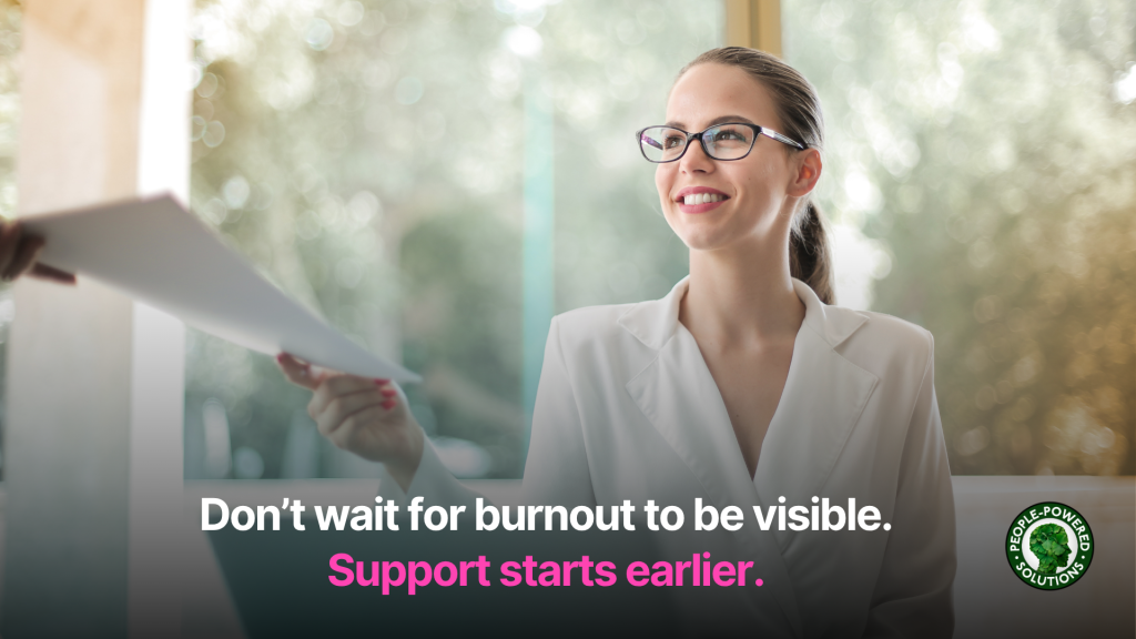 How to Support Employees Without Burning Them Out 3 Employee smiling and handing papers back to someone off screen